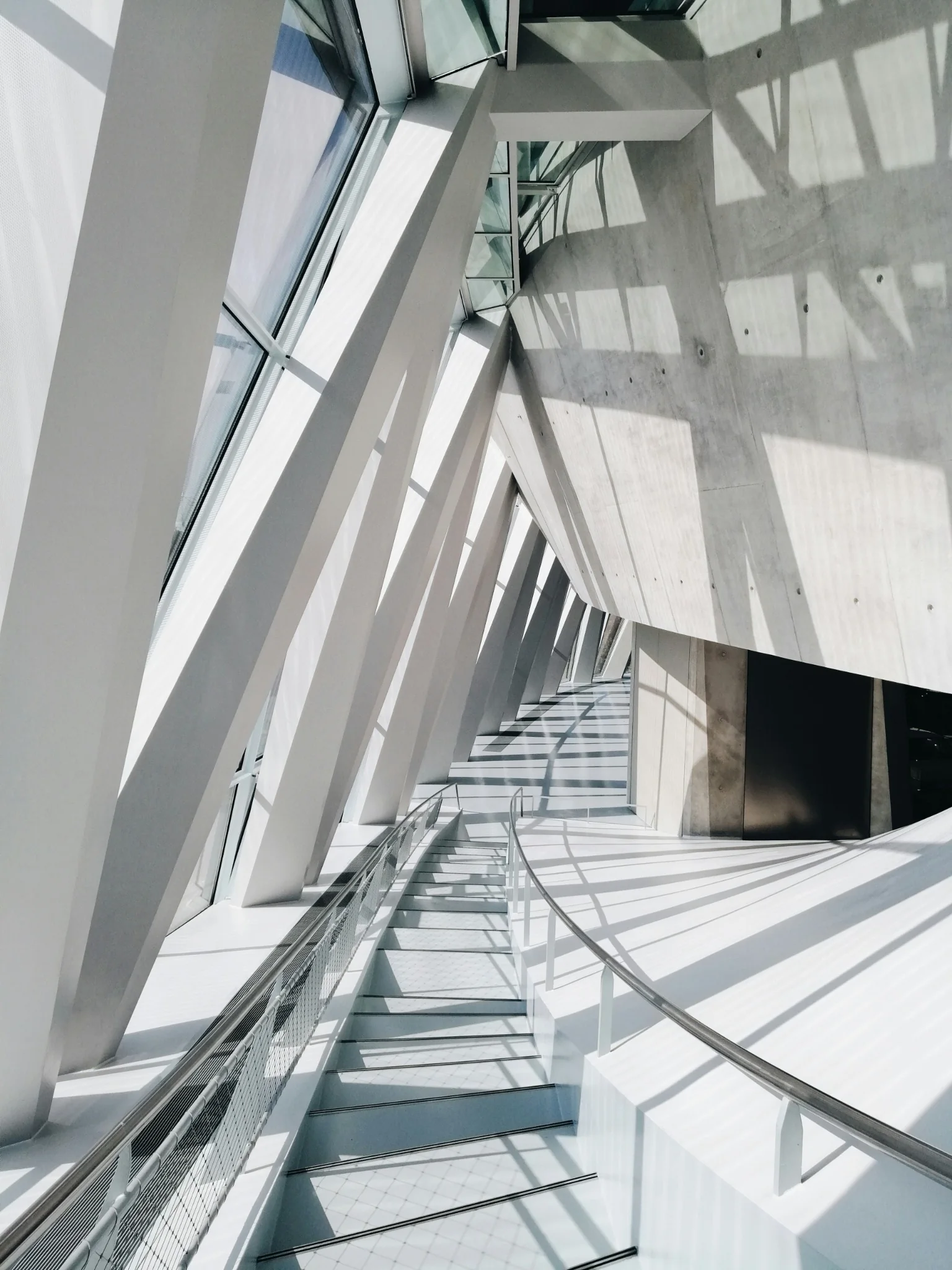 Fragment architectural lumineux en béton blanc et pierre chaude — photographie Andrea G